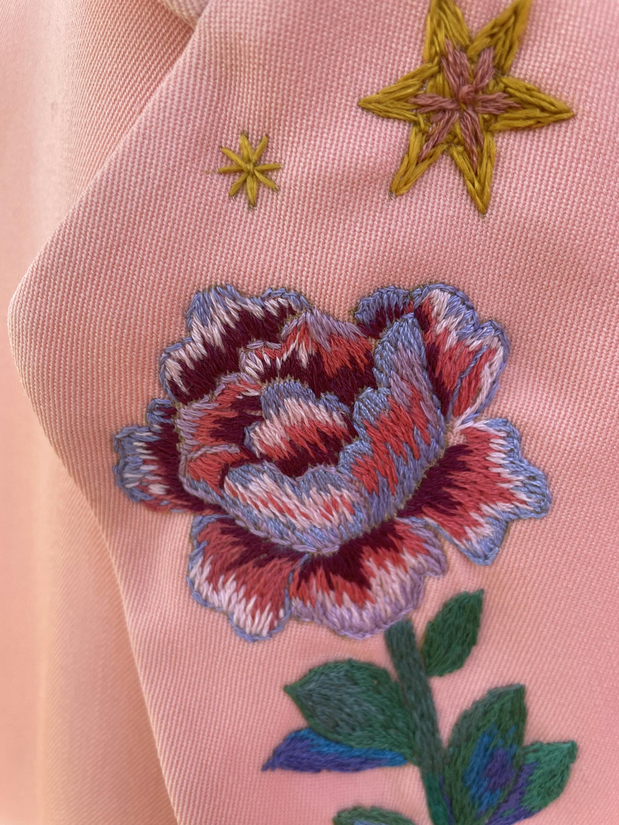 Broderie de fleur et d'étoile sur une veste rose