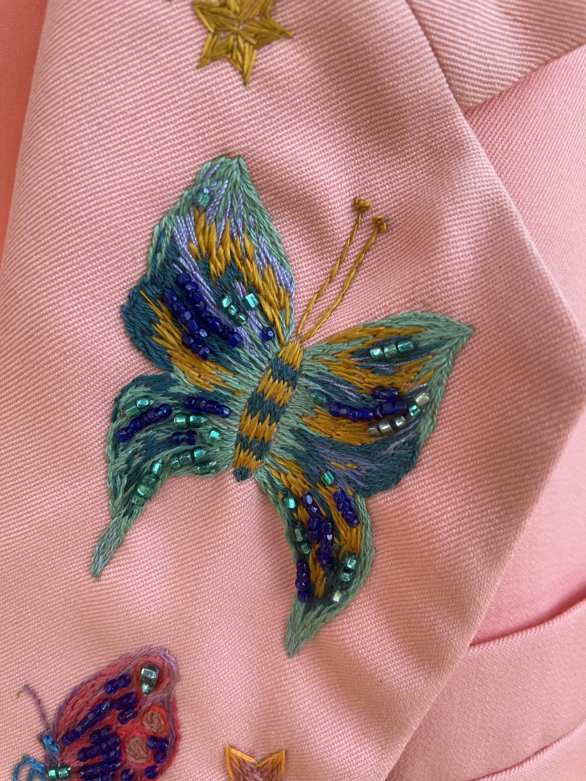 Broderie de papillon sur une veste rose